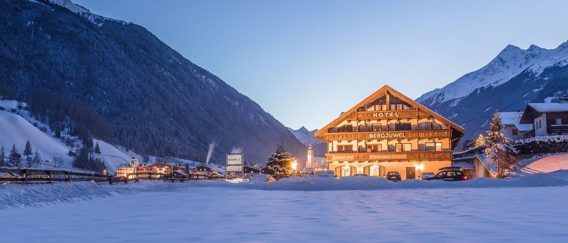 Sich erholen im Hotel in Neustift im Stubaital Beleuchtetes Hotel in verschneitem Tal mit Bergen im Hintergrund bei Dämmerung