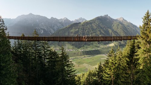 Sich erholen im Hotel in Neustift im Stubaital Hängebrücke über einem Wald mit Bergen und Tal im Hintergrund