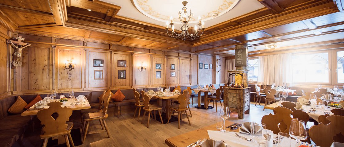 Sich erholen im Hotel in Neustift im Stubaital Traditionelles Restaurant mit Holzmöbeln und gedeckten Tischen