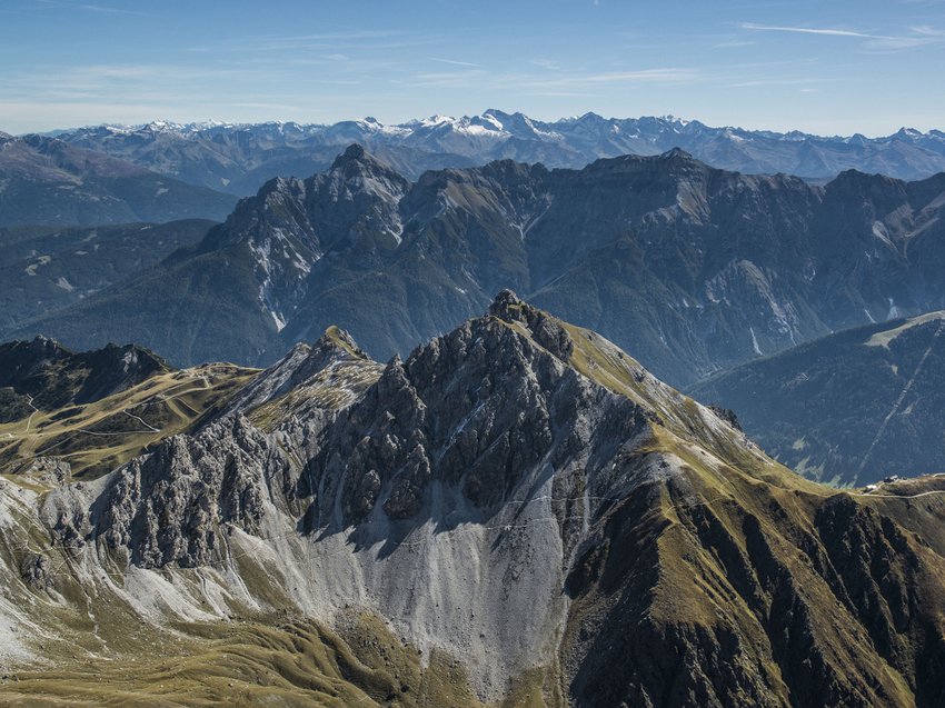 Ready for your holiday in Stubaital this summer? Mountain range with rocky peaks and green-brown meadows under blue sky