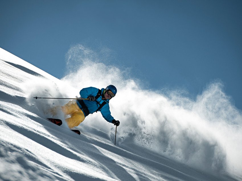 Sich erholen im Hotel in Neustift im Stubaital Skifahrer fährt steil im Pulverschnee bei klarem Himmel