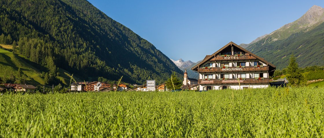 Sich erholen im Hotel in Neustift im Stubaital Hotel in einem grünen Tal mit Bergen und klarem blauem Himmel im Hintergrund