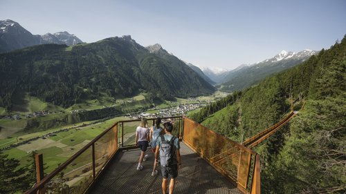 NEW! Suite M Three hikers on viewing platform overlooking bridge and green valley